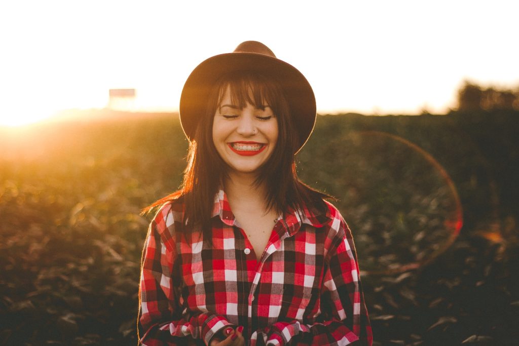 woman smiling with sun beams behind her