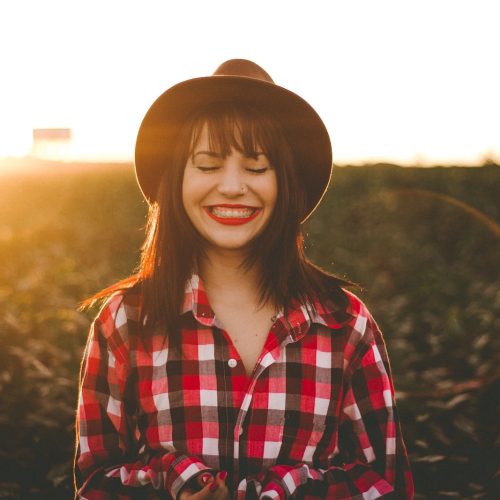 woman smiling with sun beams behind her